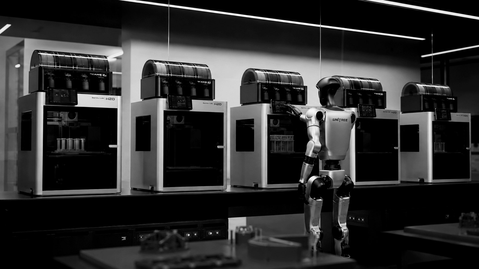 Humanoid robot operating a Bambu Lab print farm in the SOARR Industries lab